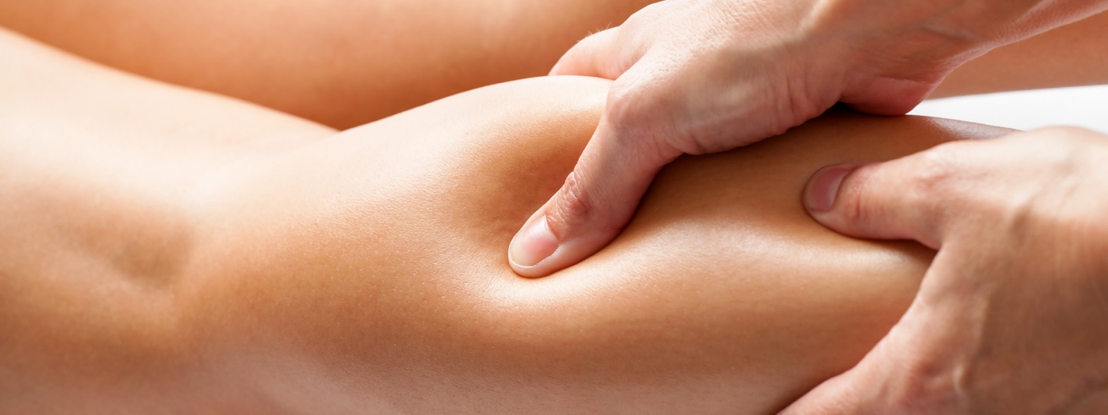 Therapist applying pressure with thumb on female calf muscle. Therapist applying pressure with thumb on female calf muscle.